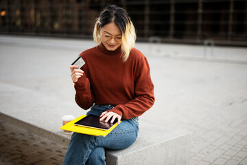 Woman making an online transaction with credit card. Young woman using digital tablet