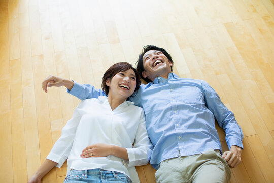 フローリングに寝転ぶ笑顔の男女