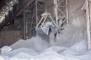 Modern technology of the bucket moves gravel, work at a cement plant. Technological work on the...