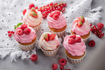 Pink cupcakes with cream and fresh berries