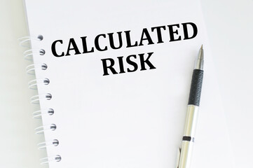 CALCULATED RISK text written on notebook on the a table