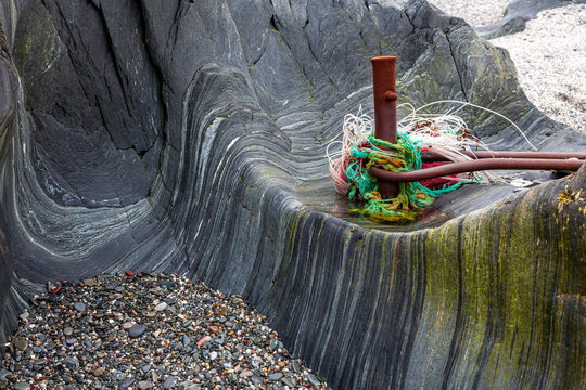 Brandung verursacht Schleifspuren an Felsen - Bootfestmacher