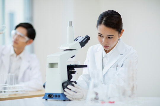 顕微鏡を操作する女性研究員