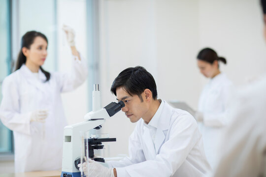 顕微鏡を覗く男性研究員