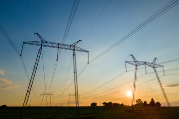 High voltage towers with electric power lines at sunset