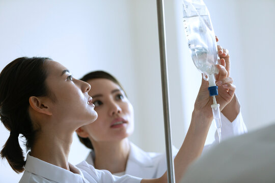 点滴の確認を行う女医と女性看護師