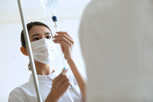 点滴の確認を行う女性看護師