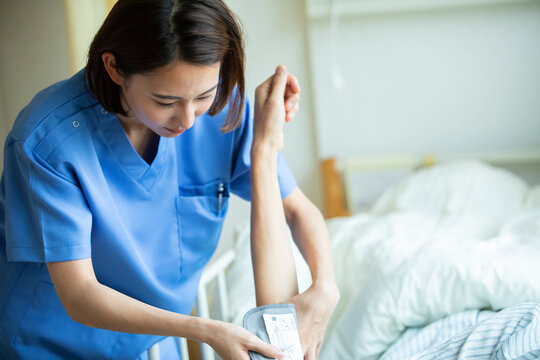 患者の血圧を測る女性看護師