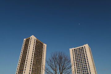 Obraz premium The urban landscape of large city. Exteriors of typical modern apartment buildings against a blue sky with clouds. 