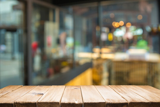 Empty dark wooden table in front of abstract blurred bokeh background of restaurant . can be used for display or montage your products.Mock up for space