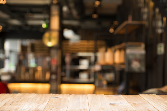 Empty dark wooden table in front of abstract blurred bokeh background of restaurant . can be used for display or montage your products.Mock up for space