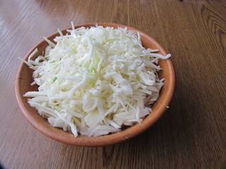 Shredded white cabbage in a clay bowl