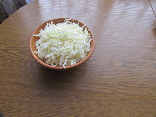 Shredded white cabbage in a clay bowl