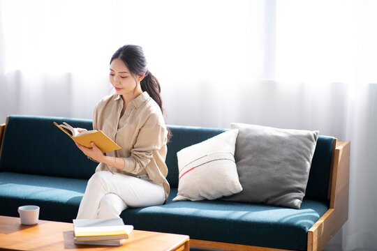 ソファーで読書をする女性