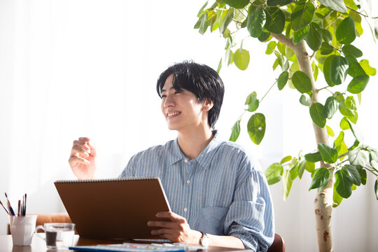 リビングで絵を描く男性