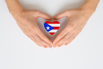 The national flag of Puerto Rico in female hands. The concept of patriotism, respect and solidarity with the citizens of Puerto Rico.