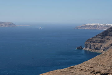 Panoramic of a ferry boat approaching the island of Santorini and the village of Oia in the background