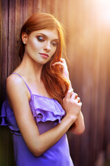 Naklejka premium Beautiful young woman posing near the wooden wall