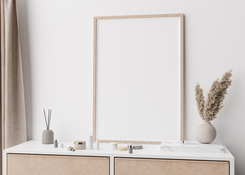 Empty vertical picture frame standing on console in modern bedroom. Mock up interior in minimalist, scandinavian style. Free, copy space for picture. Pampas grass, cosmetic bottles. 3D rendering.