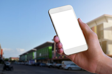 White blank touch screen smartphone holding in hand with blurr modern  buildings background. Close up view of right hand with mobile device. Mock up, copyspace, template and technology concept.