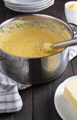 Creamy polenta fresh and homemade cooked with whisk in a pot