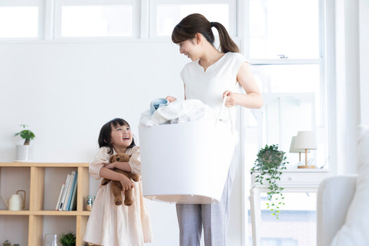 洗濯物を運ぶ母親と娘