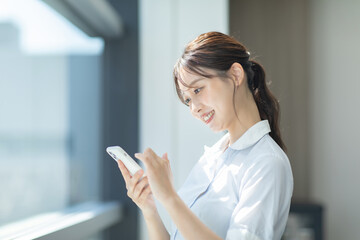 オフィスでスマートフォンを操作する女性