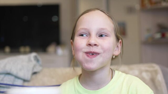 a funny little girl chews with her mouth full. good appetite and junk food in the dry. lessons of etiquette and rules of conduct at the table.