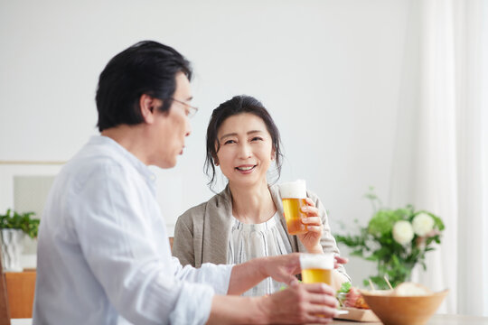 ビールを飲みながら食事をする夫婦