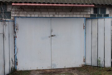 facade of a gray brick garage with iron gates closed in the street