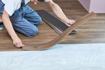 worker joining vinyl floor covering at home renovation - 493440821