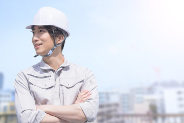 作業着姿で腕を組む見る男性　右にコピースペースあり