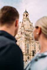 Junges Paar schaut voller Ehrfurcht auf die Dresdner Frauenkirche in Sachsen Deutschland vertikal