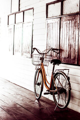 Photo old bicycle leaning against parked beside the house.