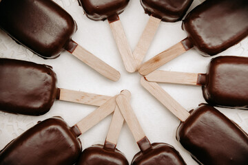 chocolate candies on white, chocolates on a stick on a plate