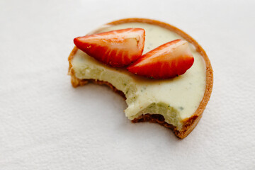 green cupcake with bite taken over white,  Tasty tartlets with juicy berries, 