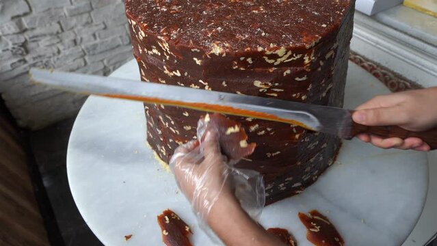 A candy maker slices cezerye, traditional Turkish candy made of carrot, sugar and coconat.  