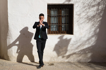 Portrait of young and handsome gipsy man dancing flamenco, dressed in black and green waistcoat...