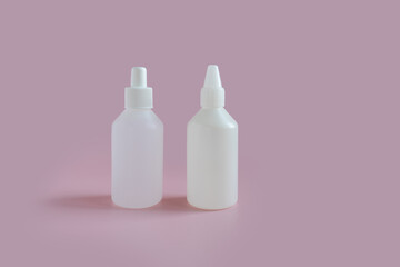 
two white medicine bottles on a pink background