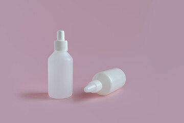 
two white medicine bottles on a pink background