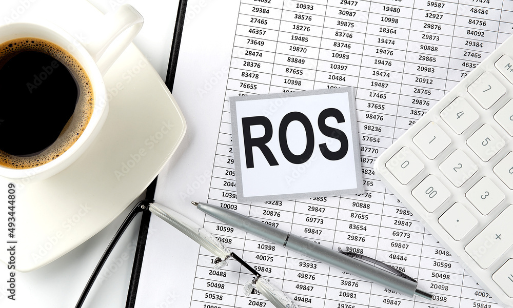 Poster ros text on sticky on chart with coffee,pen and calculator