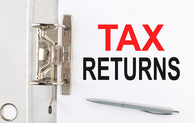 TAX RETURNS text on the paper folder with pen. Business concept