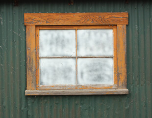 Stare okno na zielonej ścianie z blachy falistej