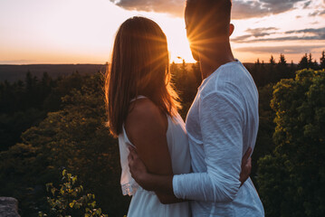 Paar blickt sehnsüchtig in Richtung  Abendsonne horizontal