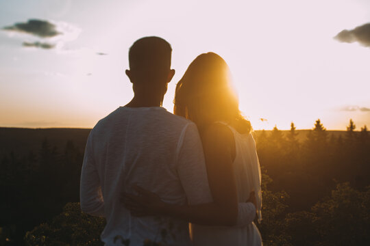 junges verliebtes Paar schaut zur Sonne am Abend und denkt an eine glückliche Zukunft
