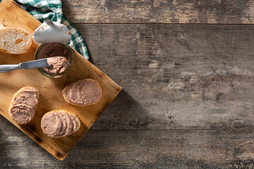 Toasted bread with pork liver pate on wooden table. Top view. Copy space