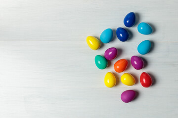 Easter eggs. Toy multicolored plastic Easter eggs on a light wooden background. Top view. Place for text