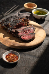 Large piece of steak with caramelized crust. Sliced steak. Medium rare steak on a wooden board