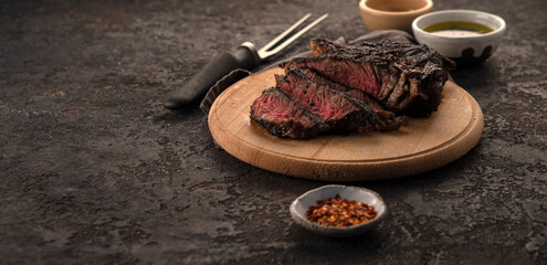 Large piece of steak with caramelized crust. Sliced steak. Medium rare steak on a wooden board