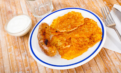 Potato pancakes with sour cream and sausage. Belorussian cuisine